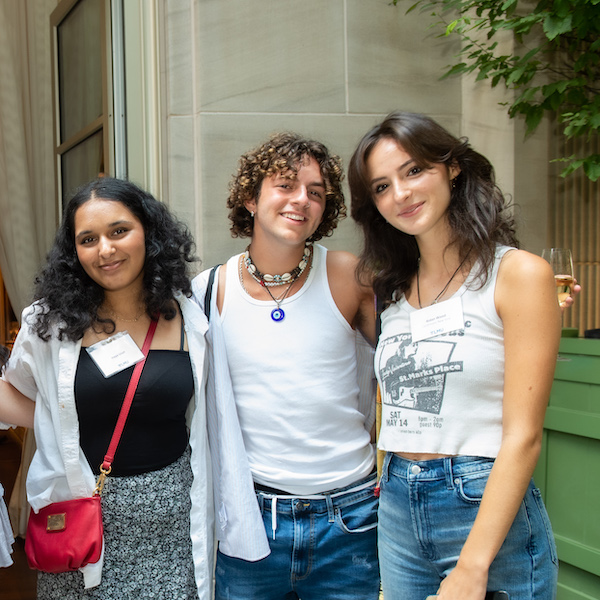 3 students standing next to`each other, looking at the camera and smiling